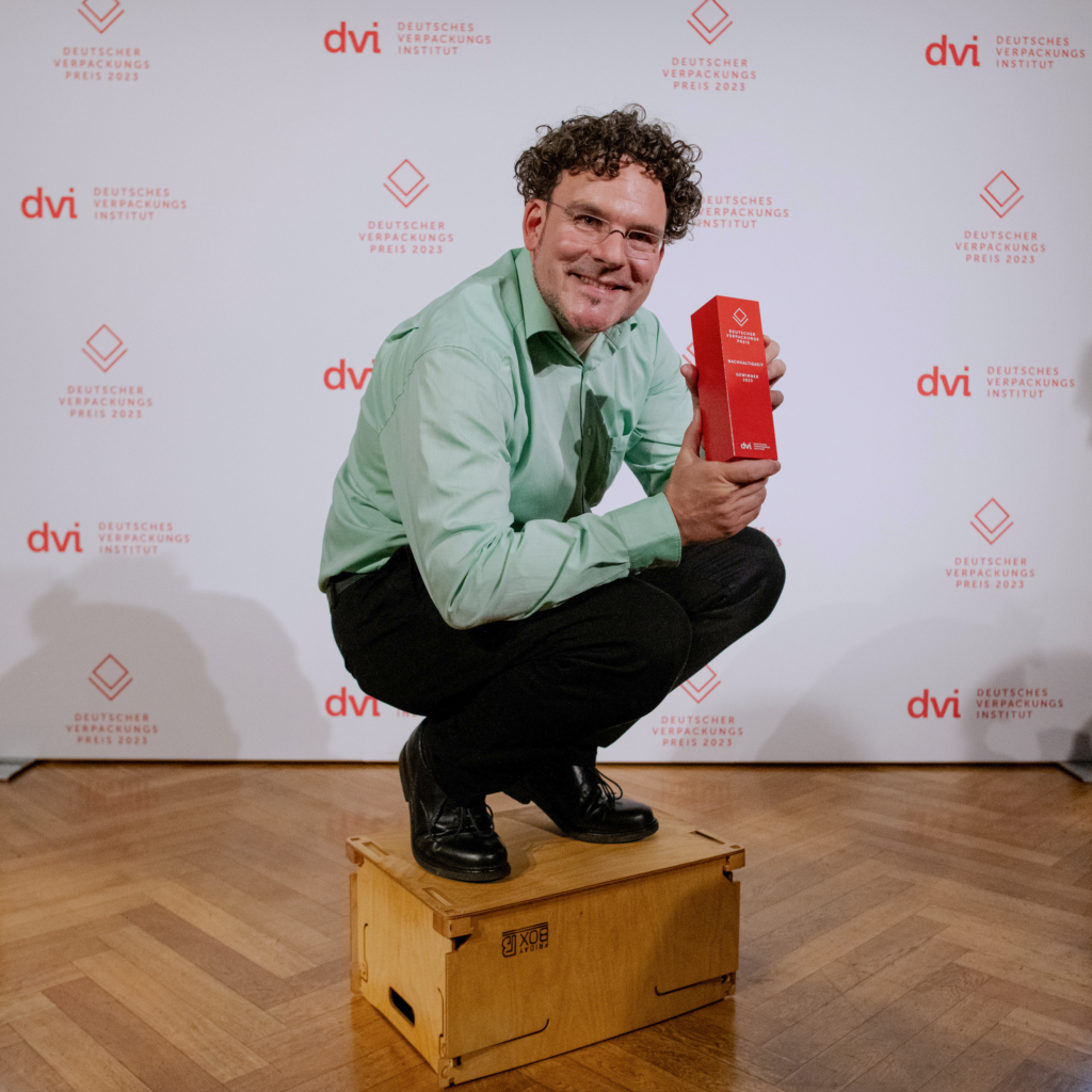 Michael mit einer der eindrucksvollssten Referenzen: dem Deutschen Verpackungspreis hockt auf einer umgedrehten FridayBOX
Foto: Andreas Domma